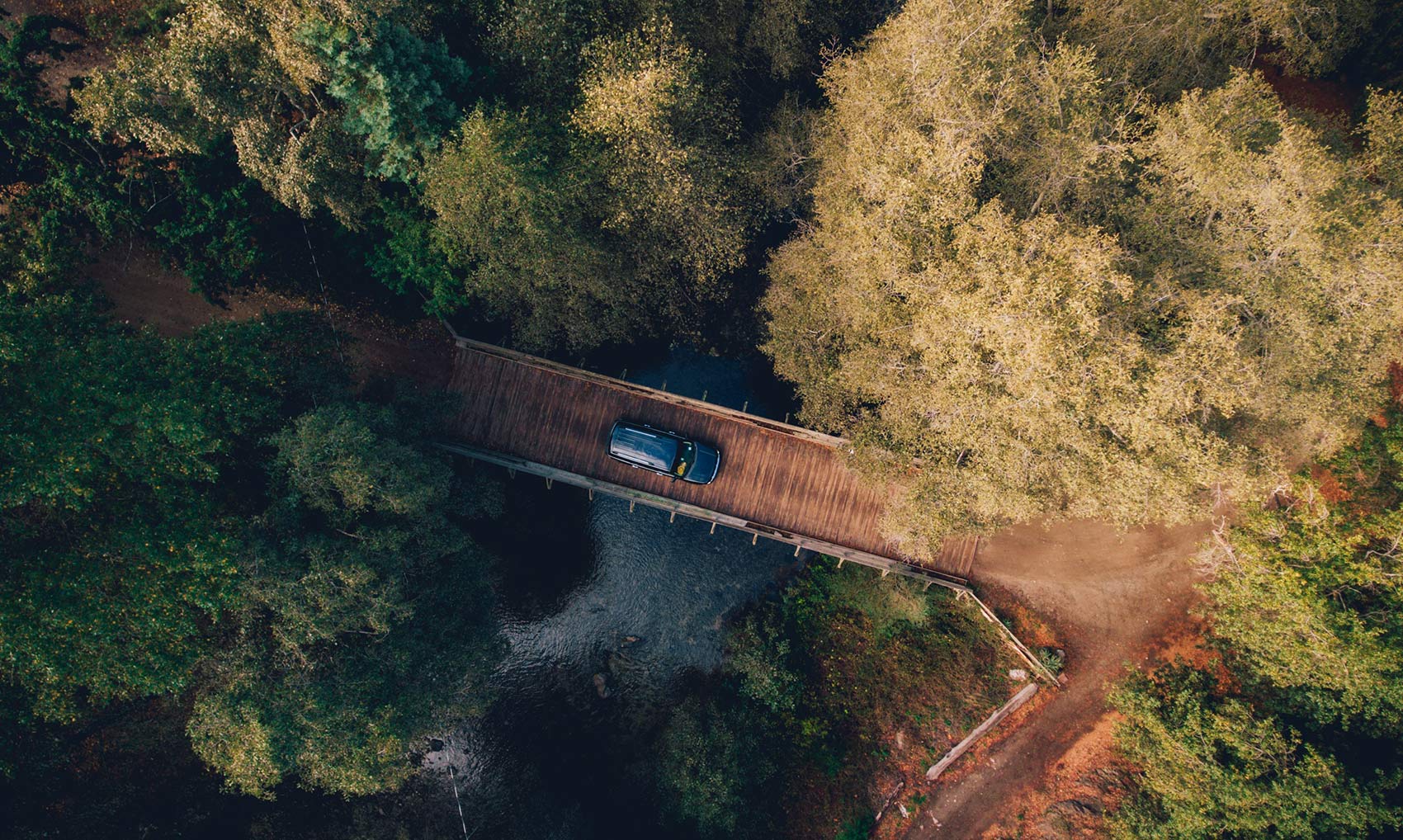 Aerial view of car on wooden forest bridge