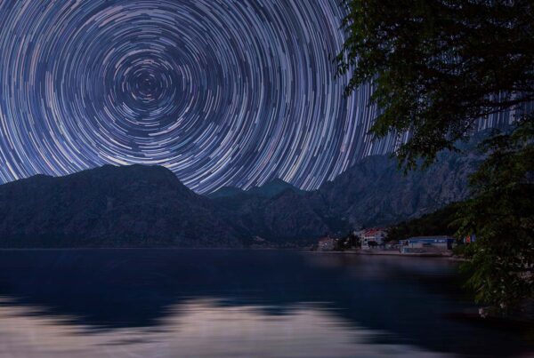 Star trails over lake and mountains